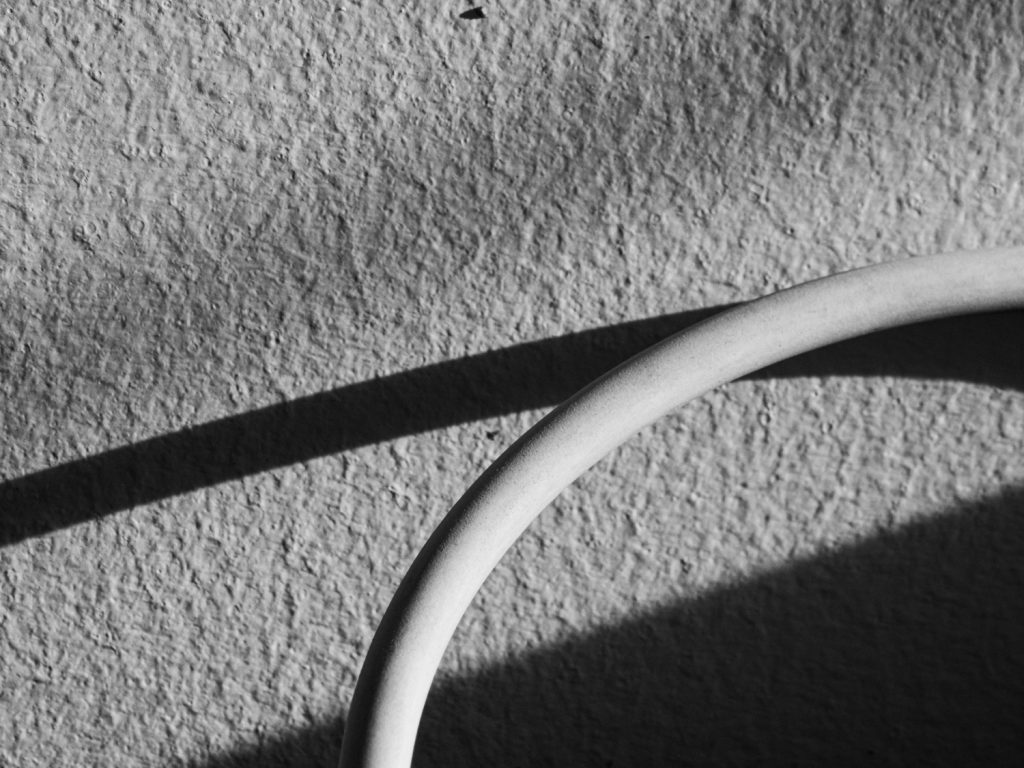 Close up shadow of wire on wall.