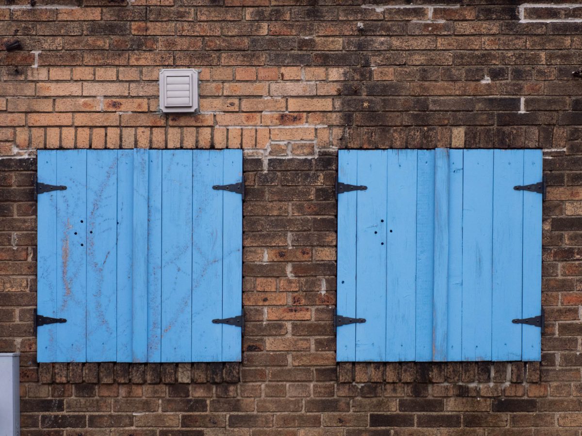 Two Blue Shutters in Brick Wall