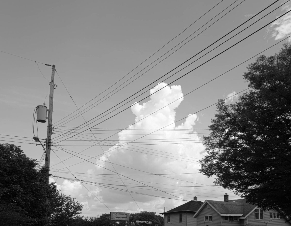 Tall cloud with wires in front of it.