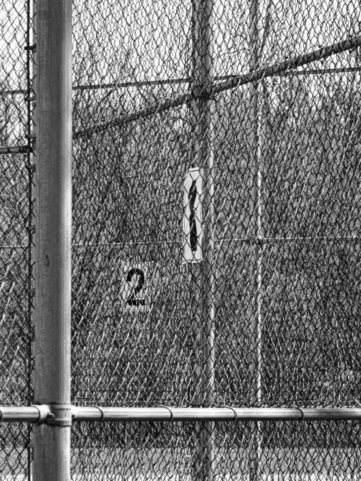 The signs "1" and "2" on chain link fence.