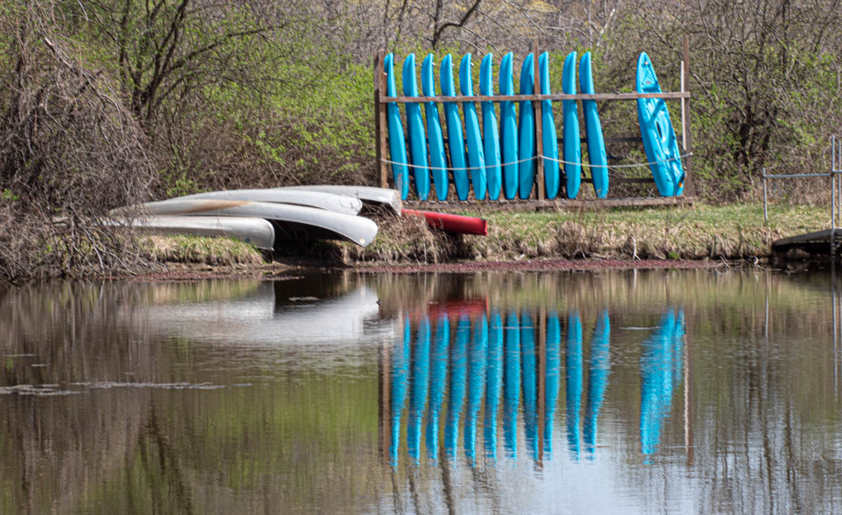 Blue kayaks reflected in water