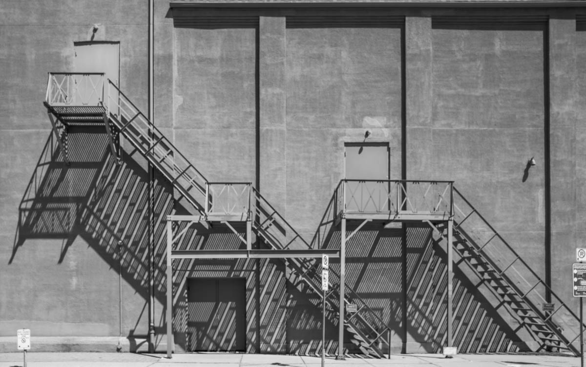 Fire escape stairway with distinct shadows.